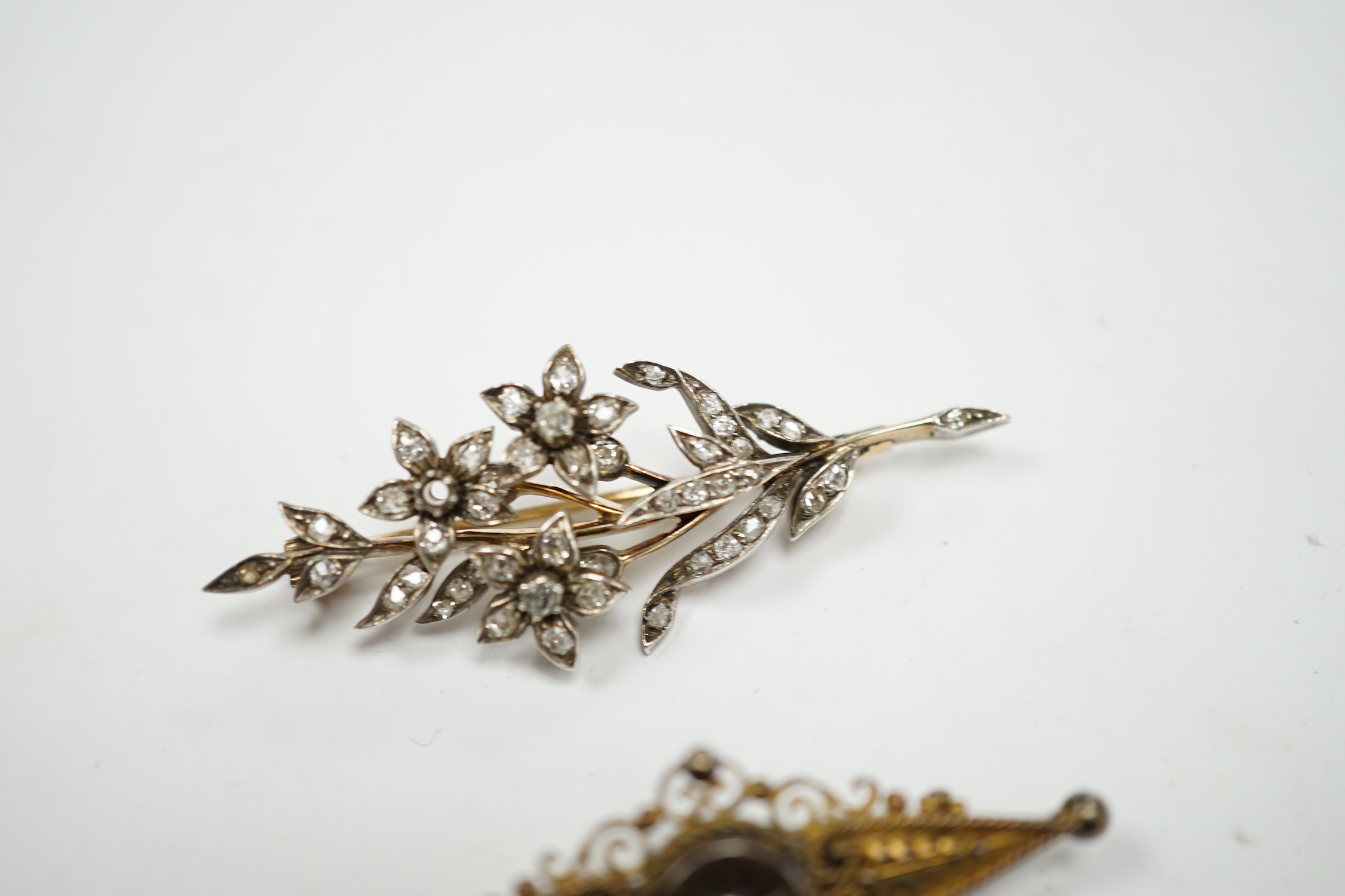 A late Victorian, yellow metal, white metal and diamond cluster set foliate spray brooch, 53mm, together with a Victorian 15ct gold and singe stone diamond set bar brooch, gross weight 11.5 grams.